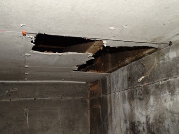 Asbestos panels broken in cellar ceiling (showing fibres). This is to side of flat in communal area.